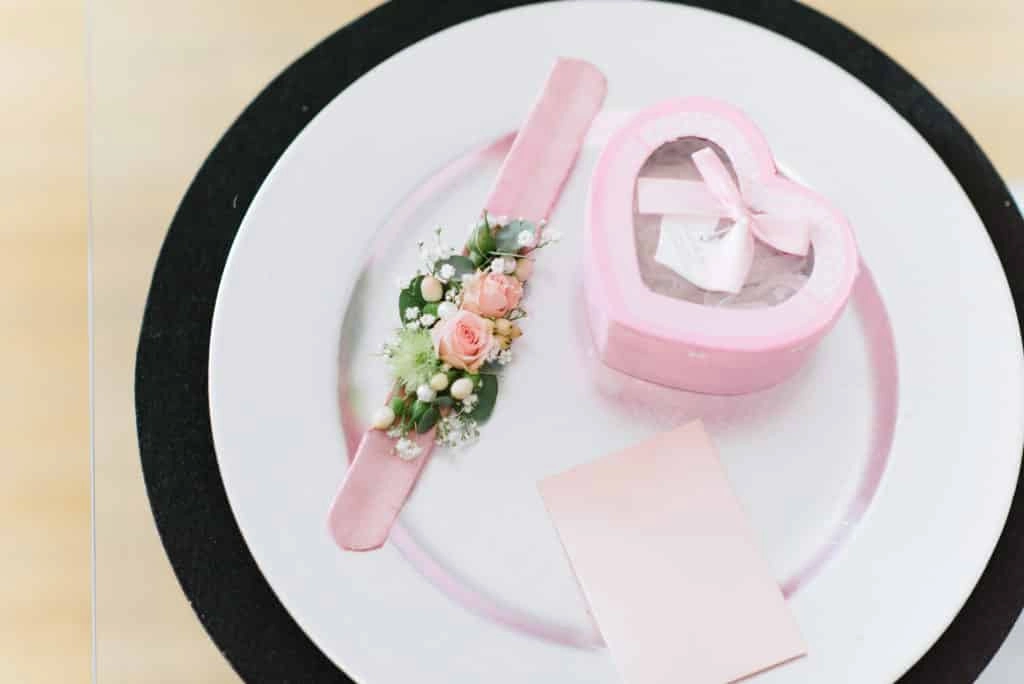 Blumenarmband und kleine rosa Herzschachtel.