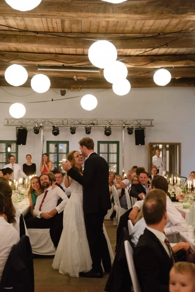 Hochzeitsgesellschaft feiert unter Lampions im Festsaal.