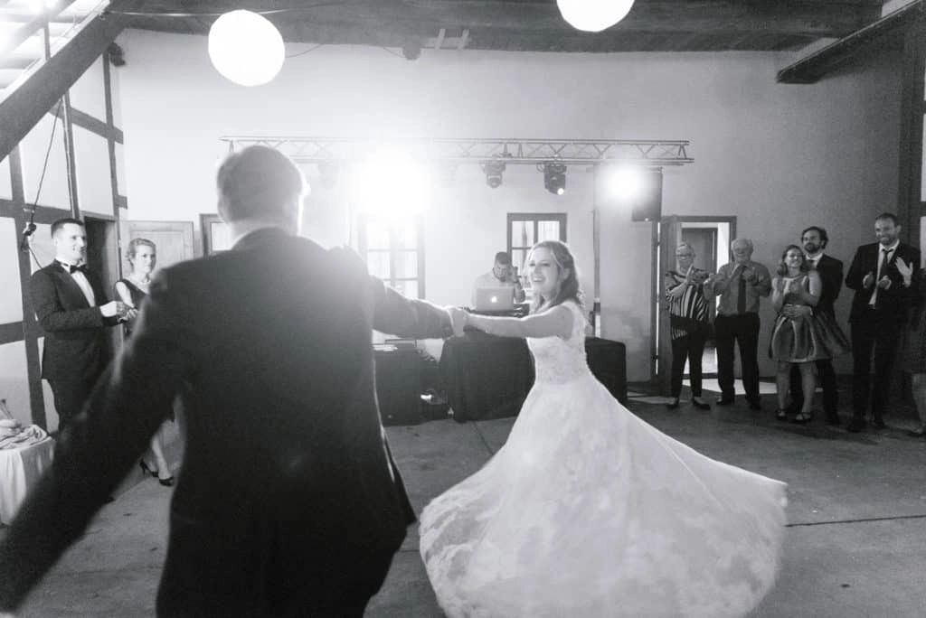 Bräutigam dreht die Braut beim Hochzeitstanz im Festsaal.