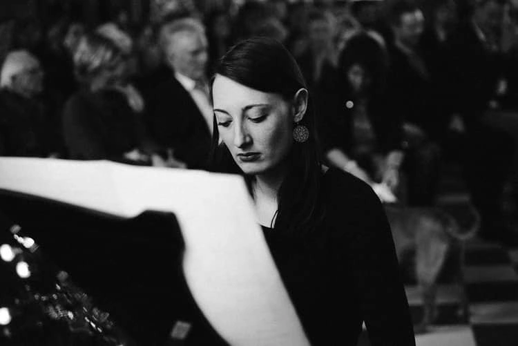 Musikerin vor den Traugästen, in Schwarz-Weiß.