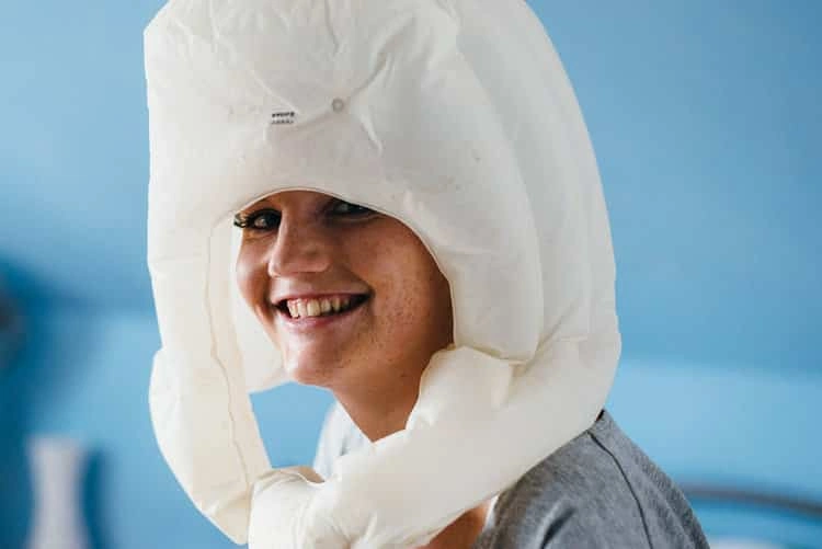 Braut lacht unter einem hochgezogenen Kleidungsstück.