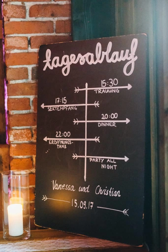 Tagesablauf der Hochzeit auf einer schwarzen Tafel.