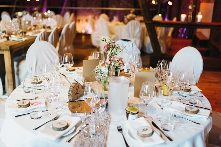 Runder Hochzeitstisch mit Gläsern und Blumenschmuck.