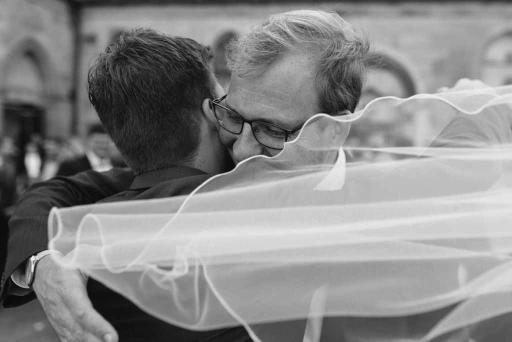 Innige Umarmung beim Hochzeitsempfang, in Schwarz-Weiß.