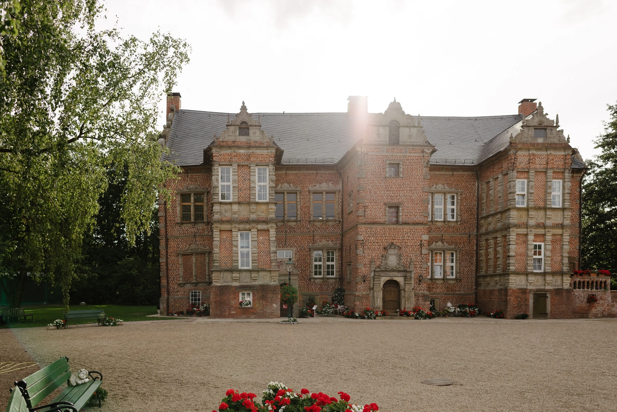 Historisches Backsteinschloss mit großem Vorplatz.