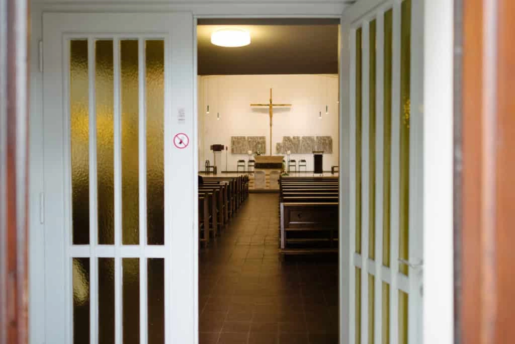Blick durch eine geöffnete Tür in den Kirchenraum.