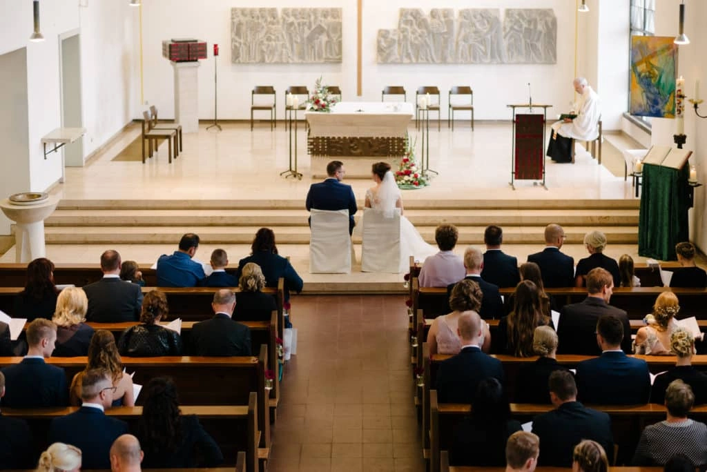 Blick über die Hochzeitsgäste zum Brautpaar am Altar.