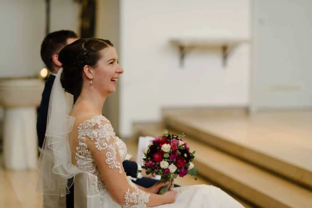 Die Braut lächelt während der Trauung in der Kirche.