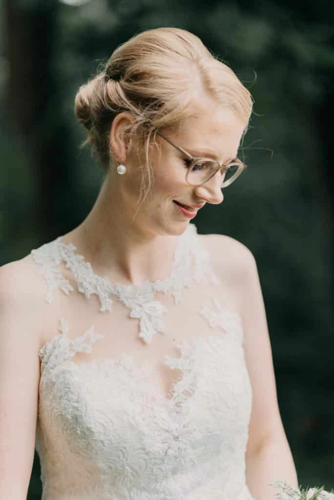 Porträt der Braut mit Brille und Spitzenkleid.