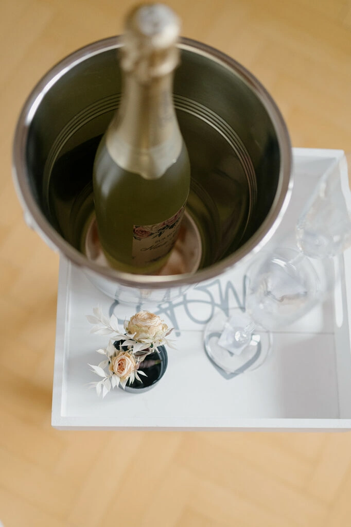 Gekühlte Sektflasche und Hochzeitskarte auf einem Tisch.