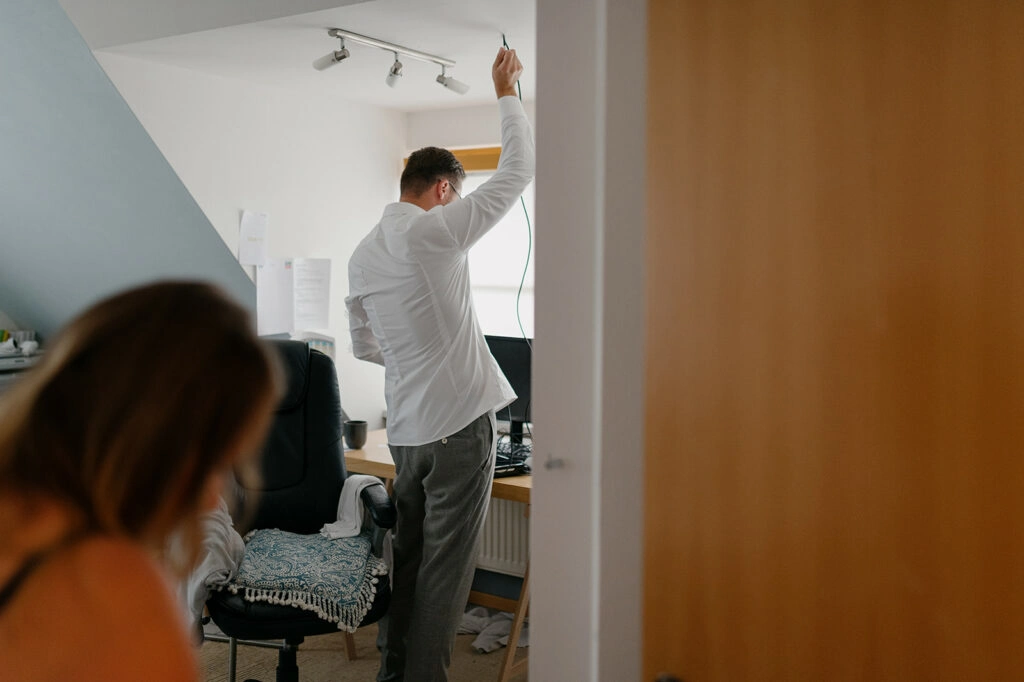 Der Bräutigam zieht sich im Schlafzimmer für die Hochzeit an.