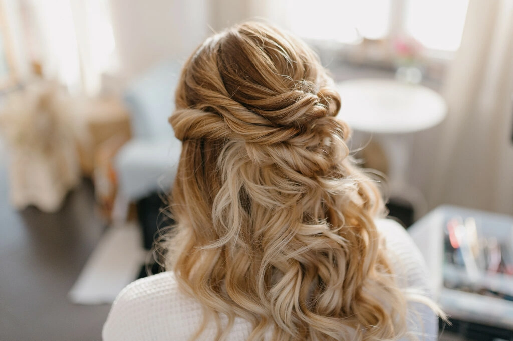 Halboffene Hochzeitsfrisur mit geflochtenen Strähnen und Locken.