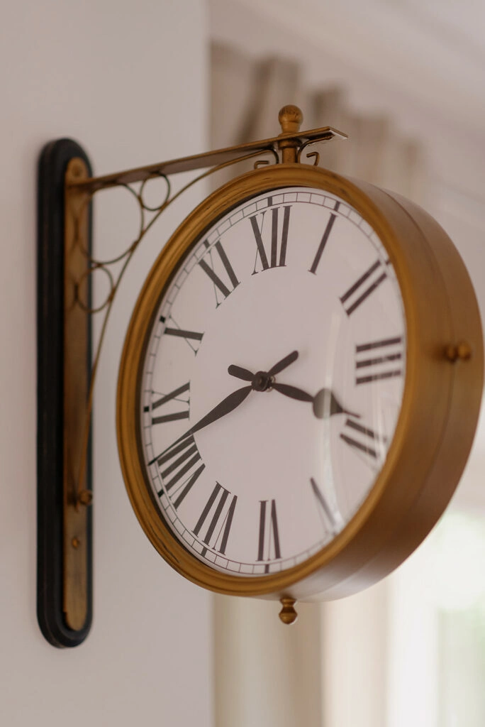 Runde Wanduhr mit römischen Ziffern.