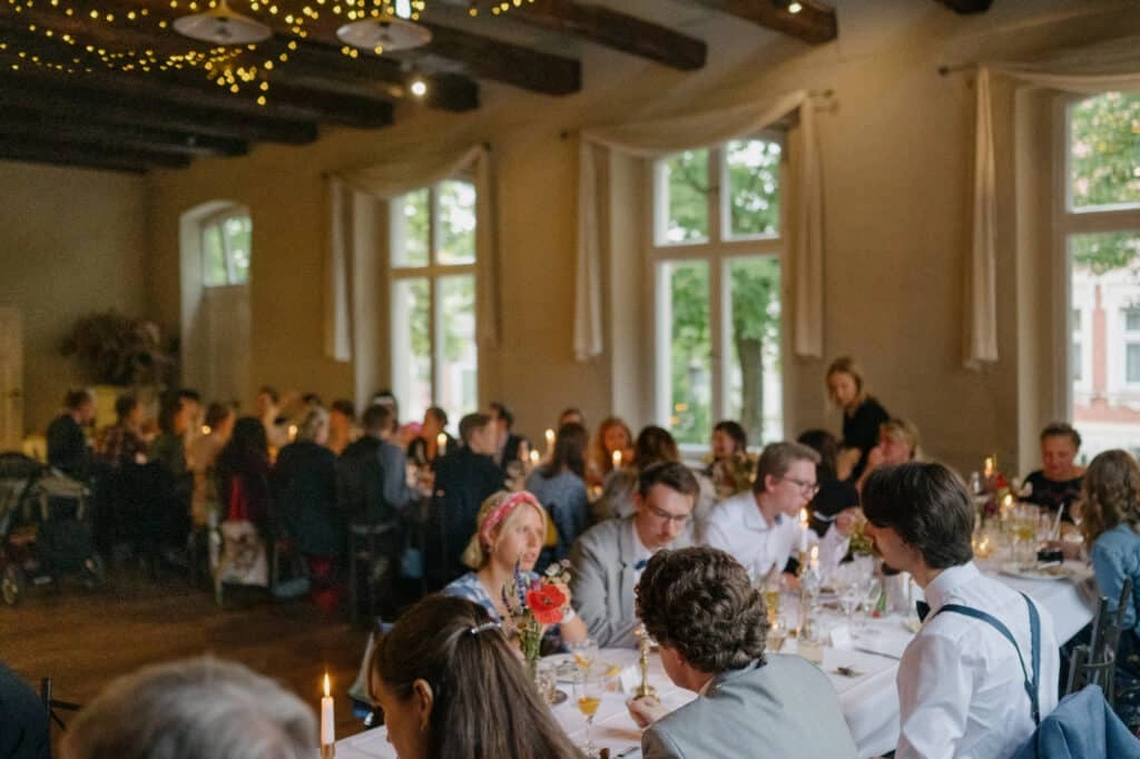 Gäste verfolgen eine Ansprache im geschmückten Saal.