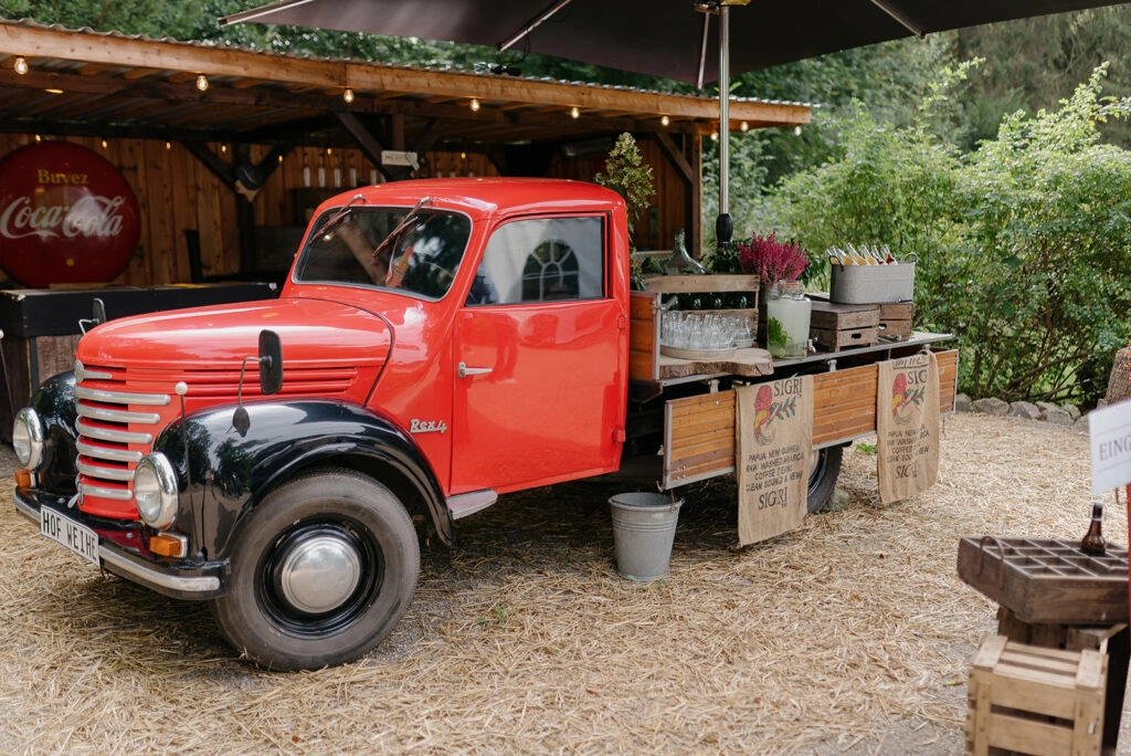 Roter Oldtimer als mobile Bar auf dem Hof.