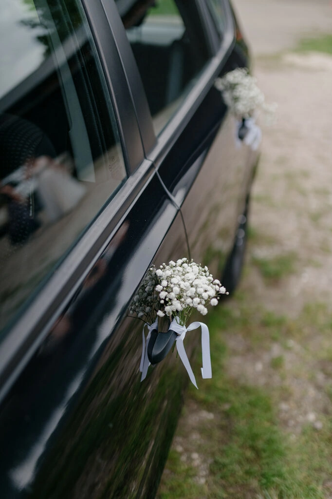 Blumenschmuck am Türgriff des Hochzeitsautos.