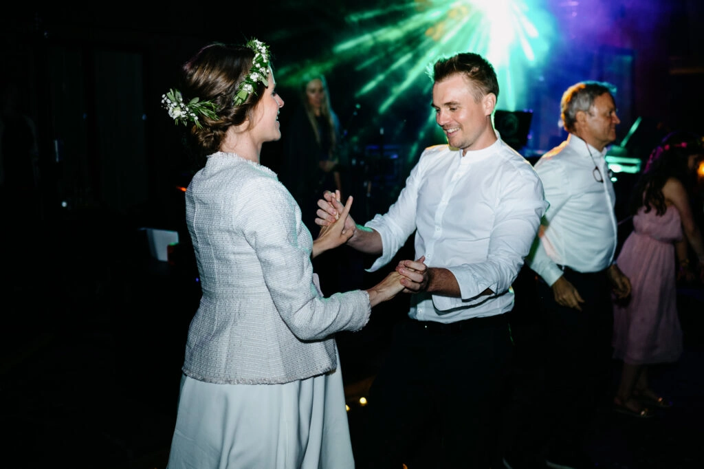 Brautpaar tanzt bei grünem Partylicht.