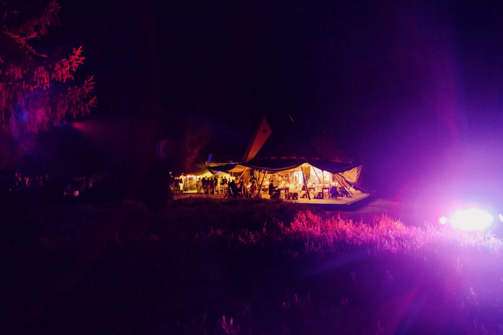 Beleuchtetes Hochzeitszelt in der Nacht.