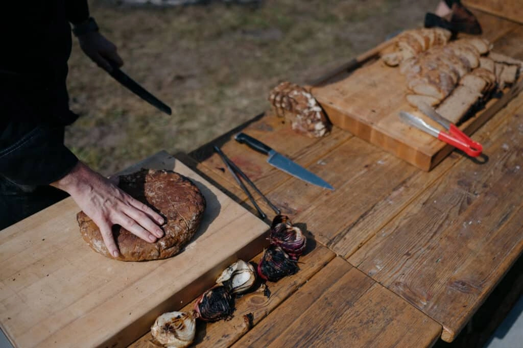 Fleisch wird auf einem großen Holzbrett geschnitten.
