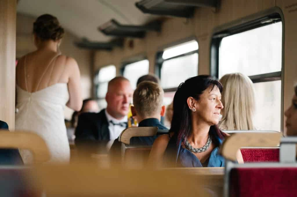 Hochzeitsgäste sitzen im Abteil einer historischen Bahn.