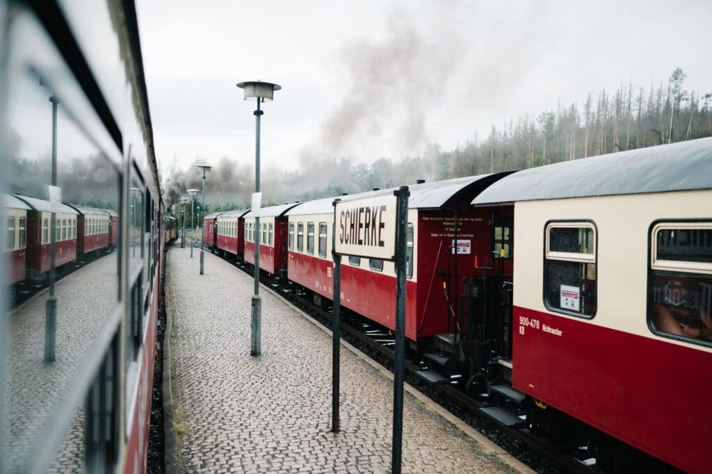 Rote und cremefarbene Wagen stehen am Bahnsteig.