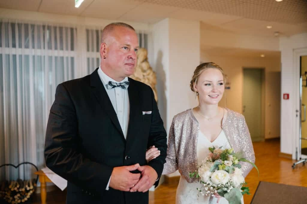 Braut geht mit einem Begleiter zur Trauung.