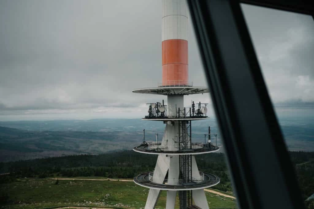 Blick durch das Fenster auf einen Sendeturm und die Landschaft.