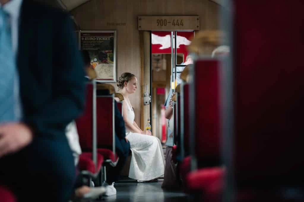 Braut sitzt im Abteil einer historischen Bahn.