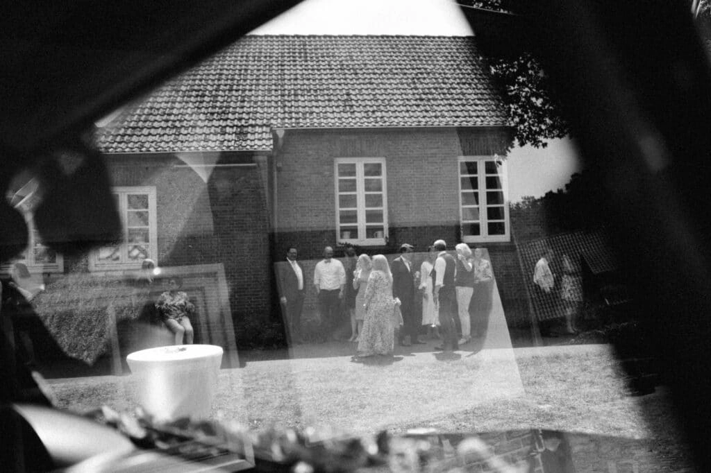 Hochzeitsszene spiegelt sich in einem Fenster, in Schwarz-Weiß.