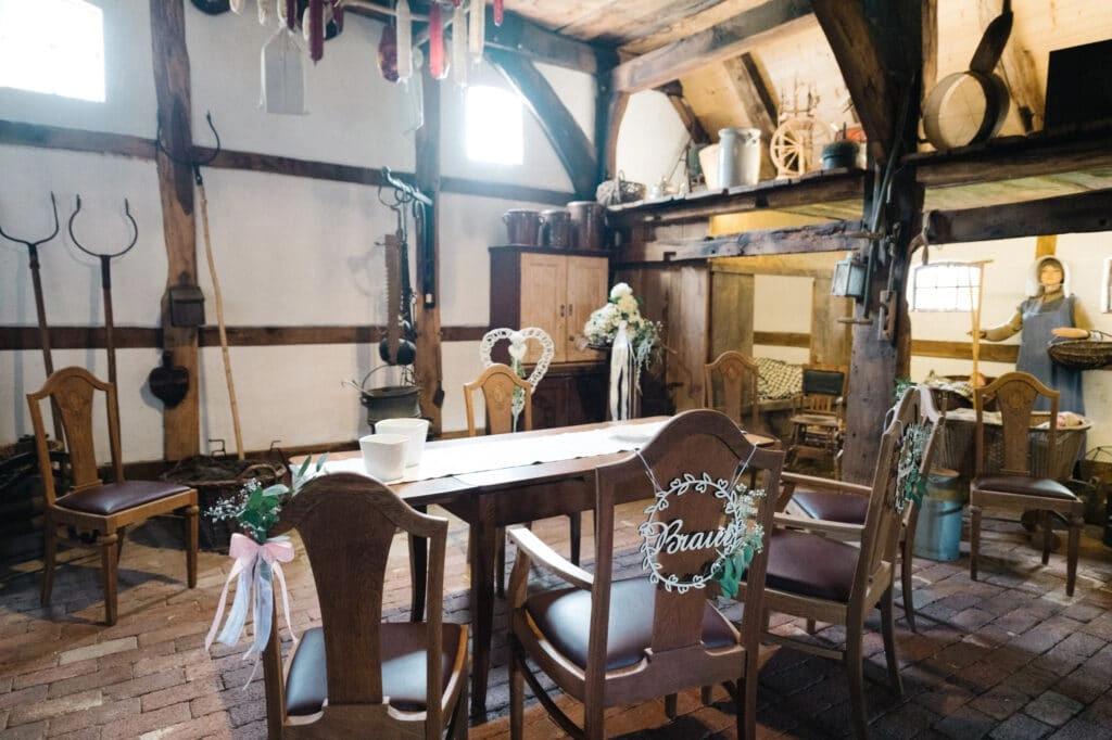 Rustikales Trauzimmer mit Holzbalken und gedecktem Tisch.