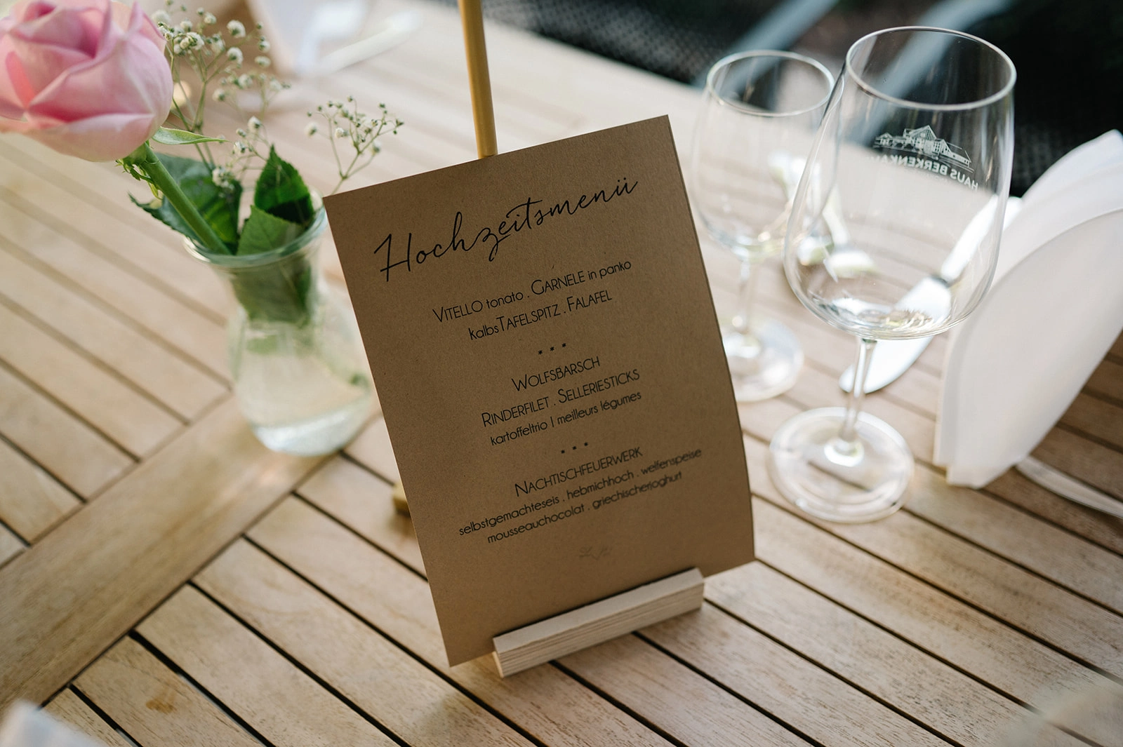 Hochzeitsmenü auf einer braunen Karte am Holztisch.