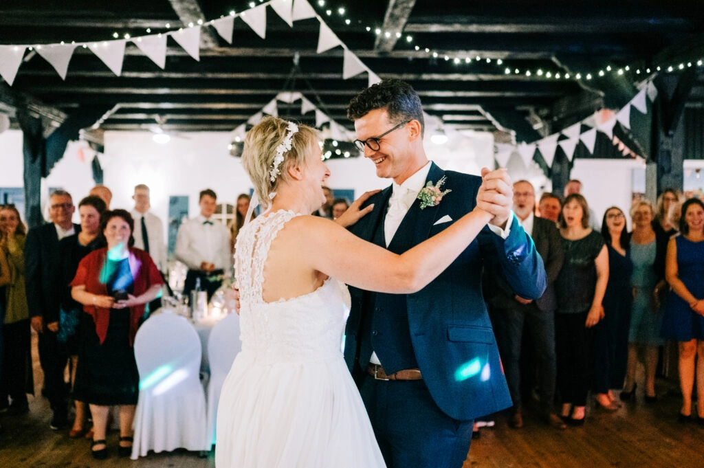Brautpaar beginnt den Hochzeitstanz vor seinen Gästen.