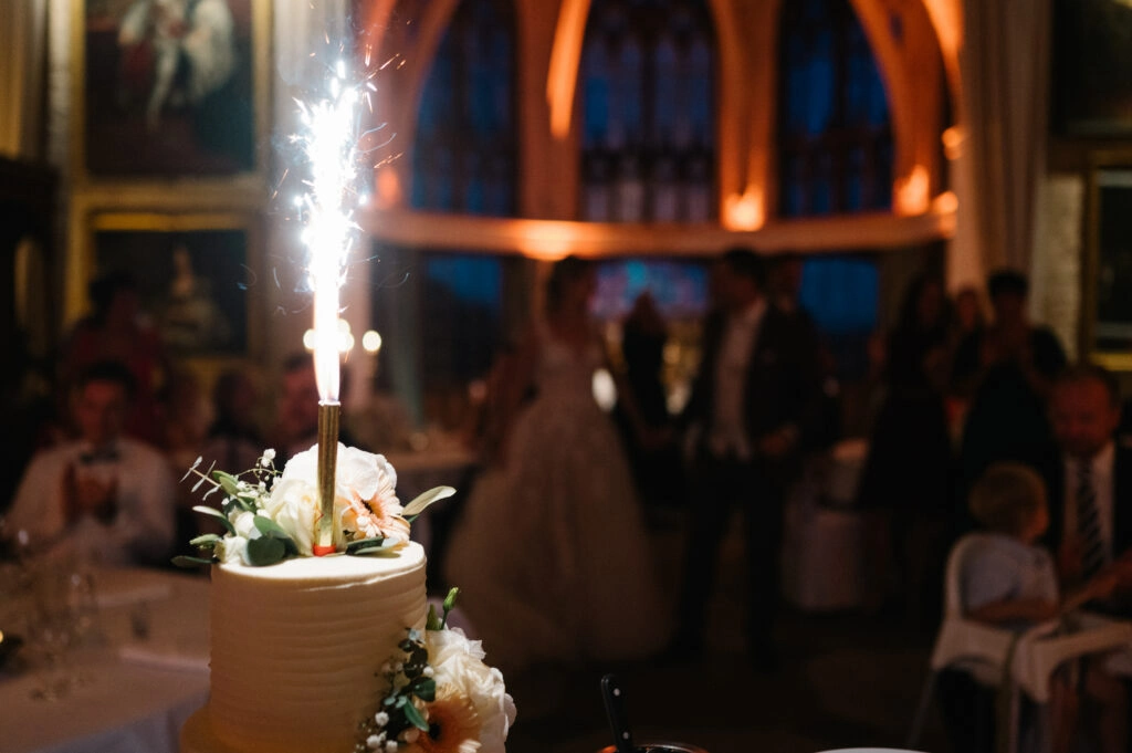 Hochzeitstorte mit brennender Wunderkerze.