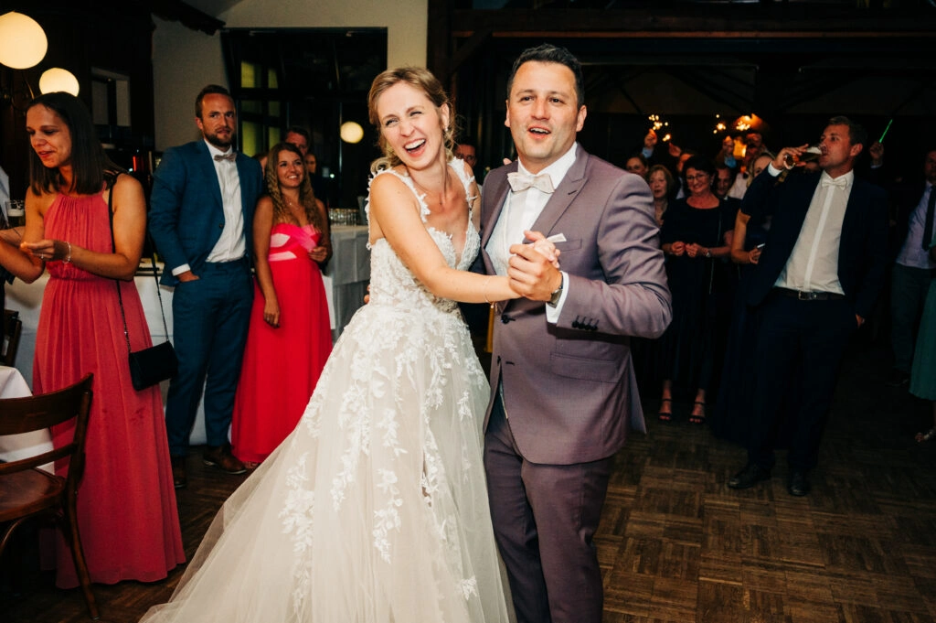 Brautpaar lacht beim Hochzeitstanz.