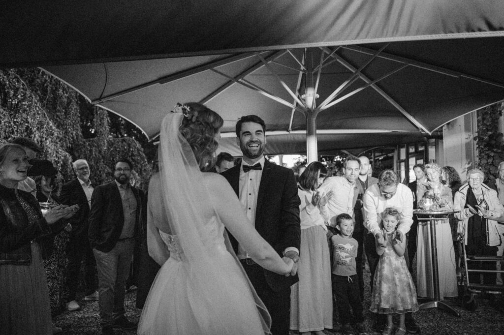 Hochzeitstanz vor den Gästen, in Schwarz-Weiß.