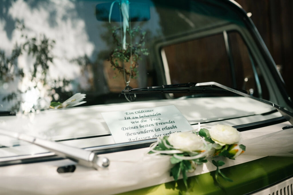 Blumenschmuck auf der Motorhaube eines Hochzeitsbusses.