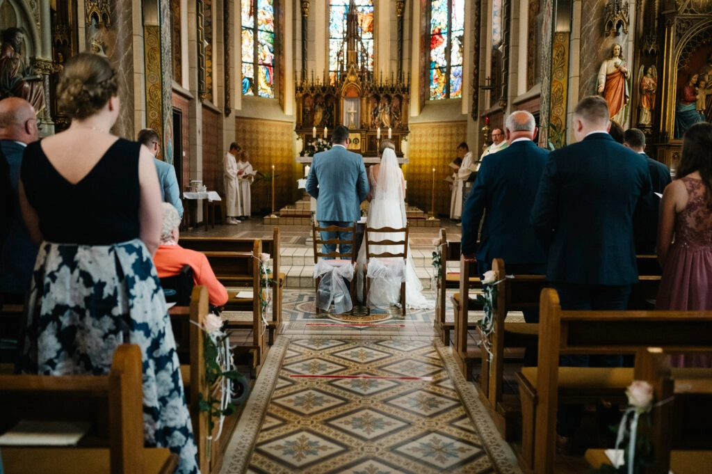 Brautpaar geht durch den Mittelgang der Kirche.