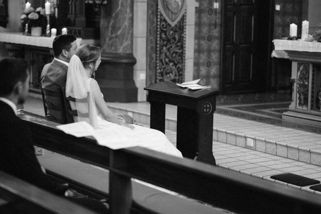 Brautpaar sitzt vor dem Altar, in Schwarz-Weiß.