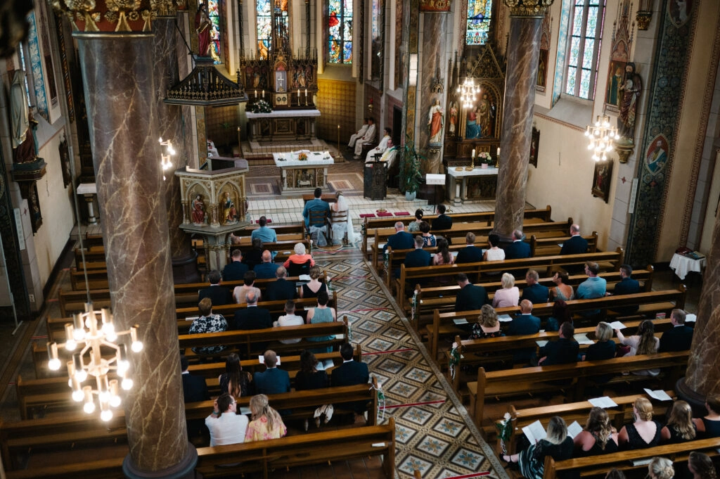 Blick von oben auf die Hochzeitsgäste im Kirchenschiff.