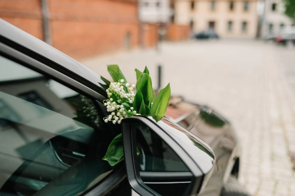 Blumenschmuck am Außenspiegel des Hochzeitsautos.