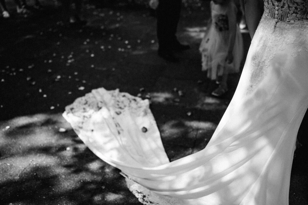 Schleppe des Brautkleids im Schatten, in Schwarz-Weiß.