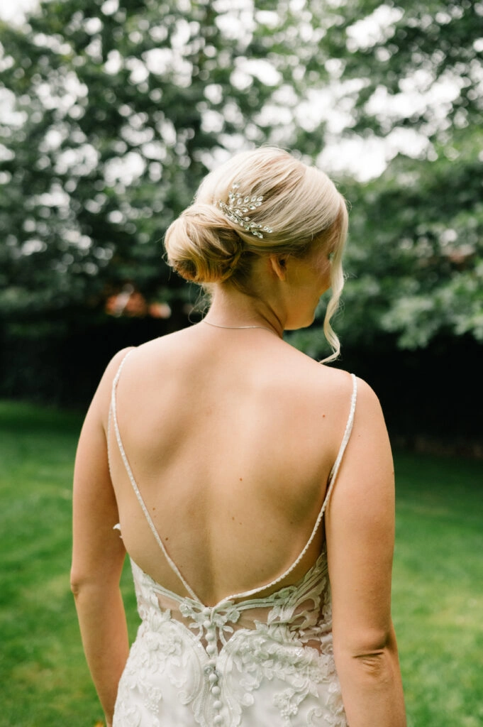 Rückenansicht der Braut mit Spitzenkleid und Hochsteckfrisur.