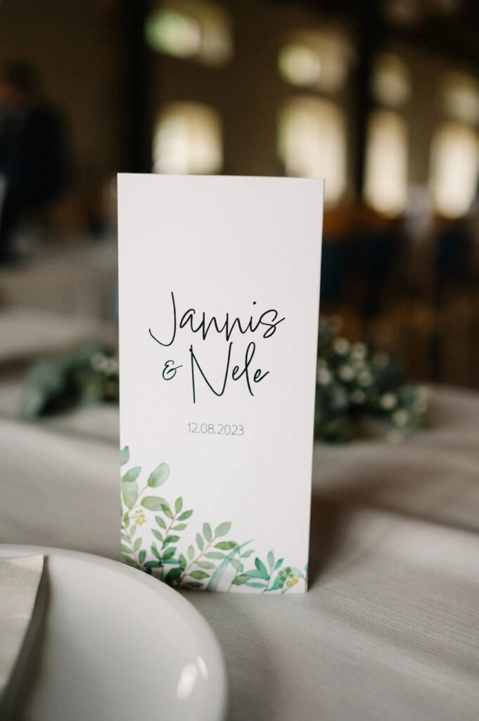 Schlichte Hochzeitspapeterie auf einem gedeckten Tisch.