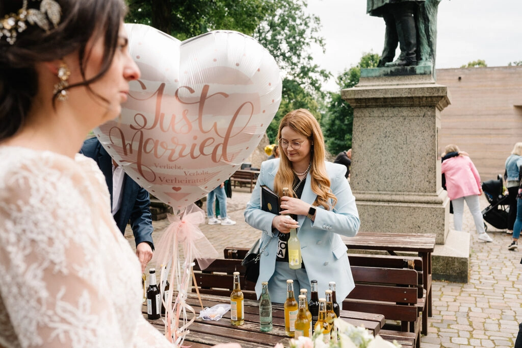 Braut neben einem herzförmigen Just-Married-Luftballon.