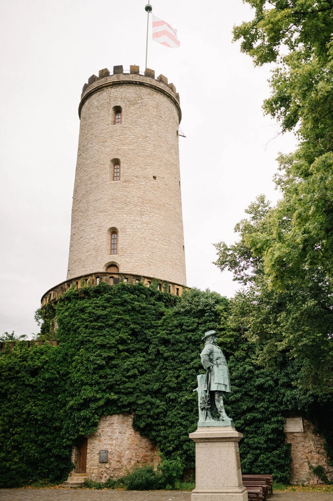 Turm der Sparrenburg mit Denkmal im Vordergrund.