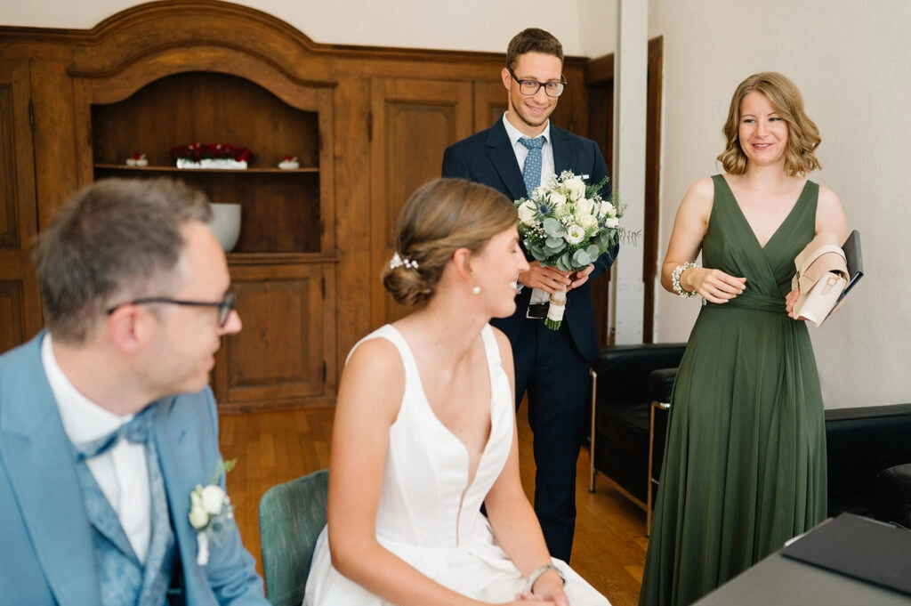 Brautpaar sitzt lächelnd im Trauzimmer.