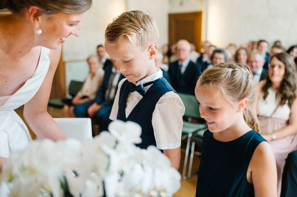 Kinder stehen mit der Braut am Trautisch.