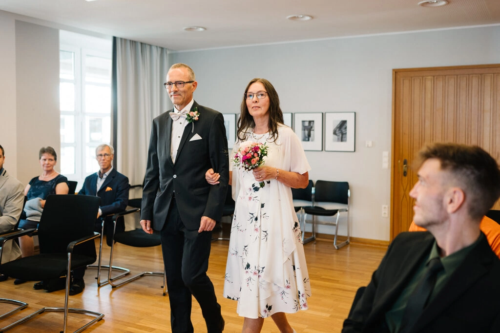 Brautpaar betritt den hellen Trausaal.