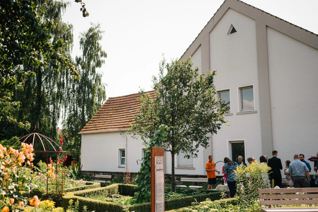 Hochzeitsempfang neben einem hellen Gebäude im Garten.
