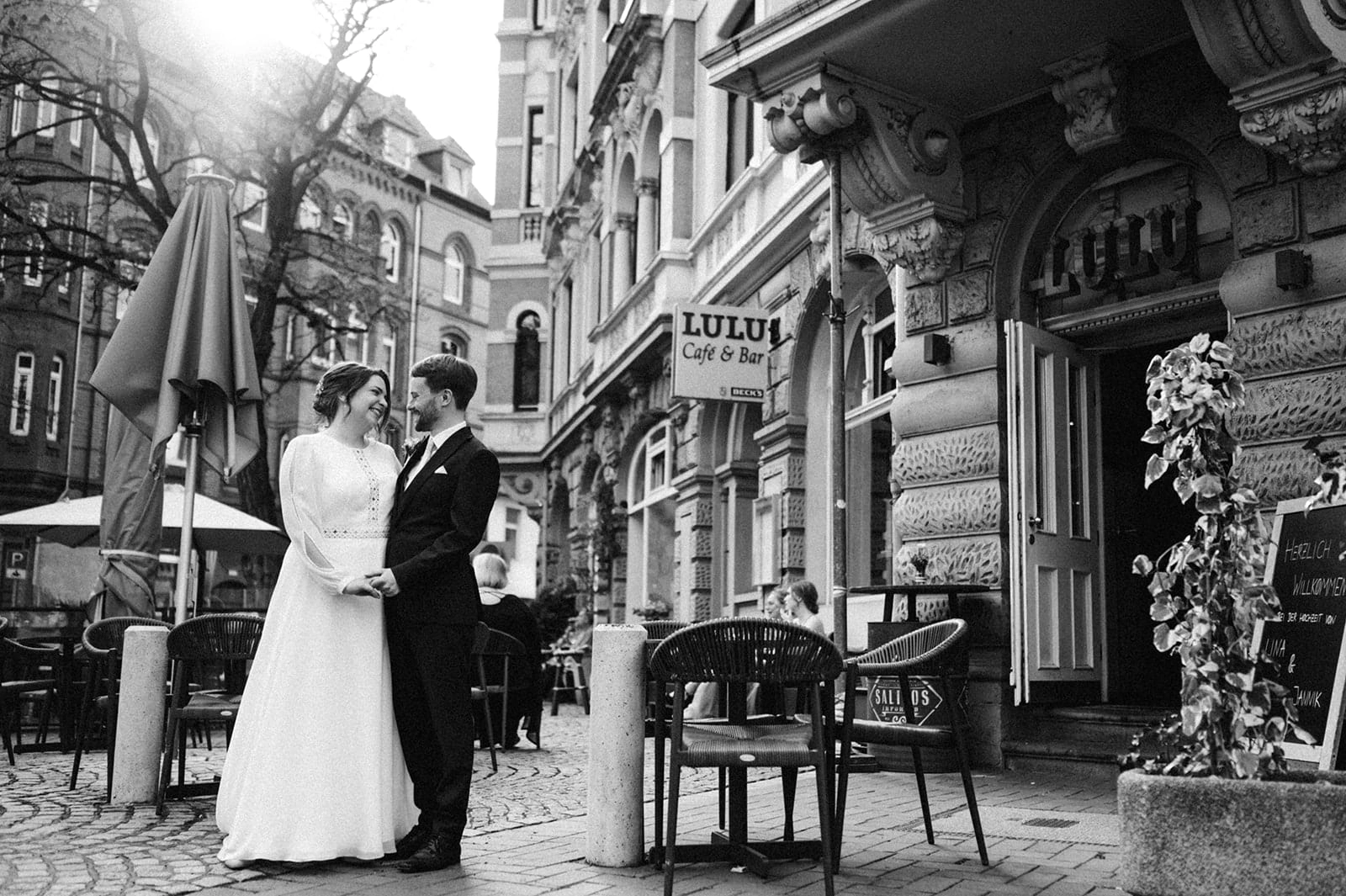 Brautpaar vor dem Restaurant, in Schwarz-Weiß.